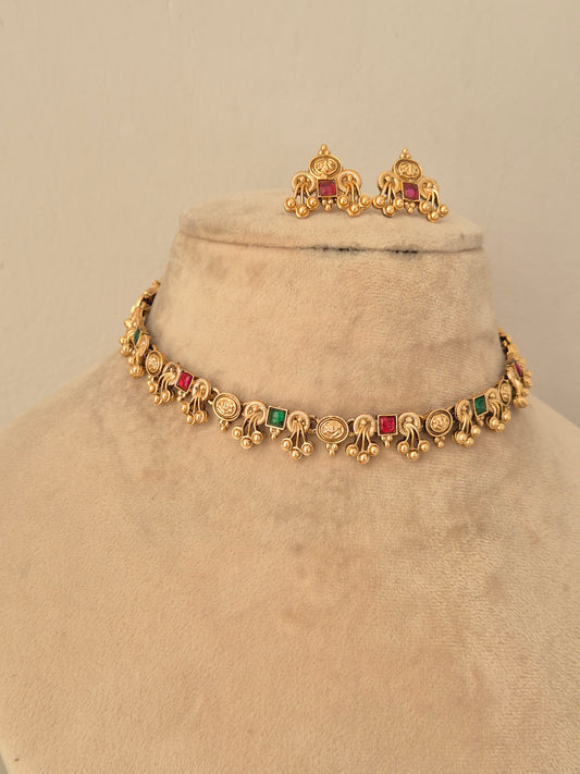 Ethnic gold choker necklace set embellished with pink, red, and green stones