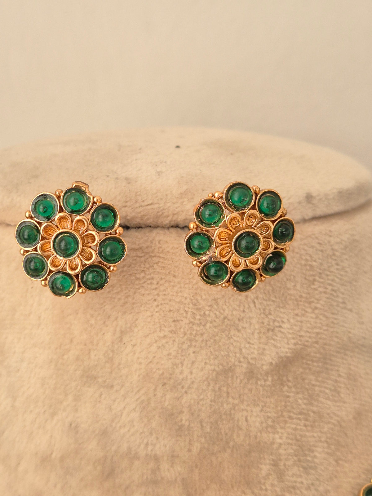 Gold-toned circular floral stud earrings with green stone embellishments from the Gaurika necklace set