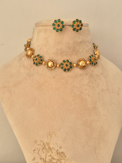 Gaurika gold choker necklace set with green stone floral motifs and matching earrings