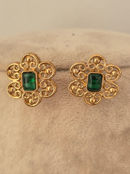 Ethnic gold floral stud earrings featuring green stone centers