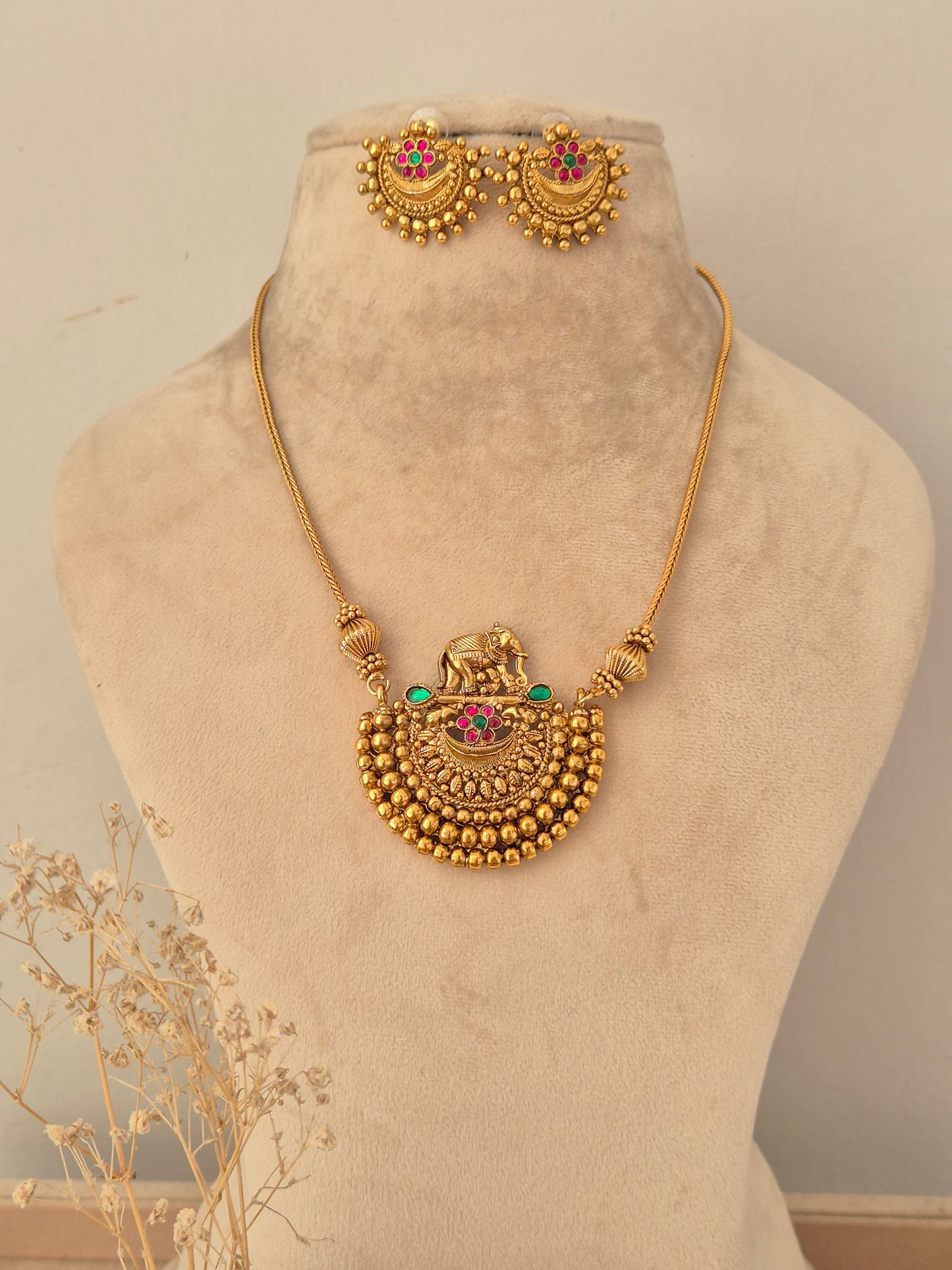 Antique gold-toned long chain necklace with an intricate elephant motif and beaded crescent pendant