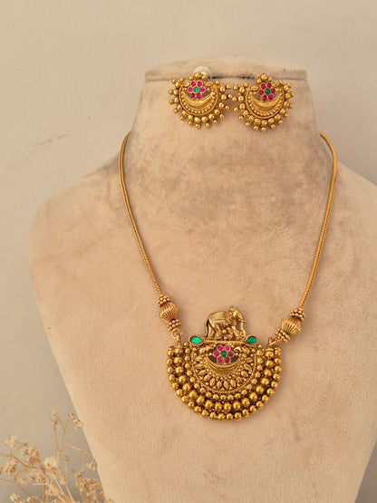 Traditional gold elephant motif pendant necklace set with pink and green stone accents
