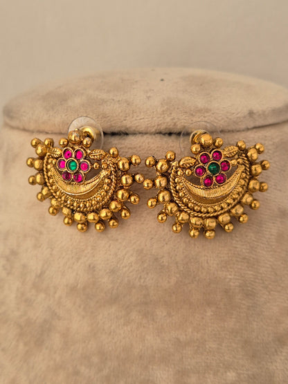 Antique gold-toned crescent stud earrings featuring textured bead trim and central pink and green stone flowers