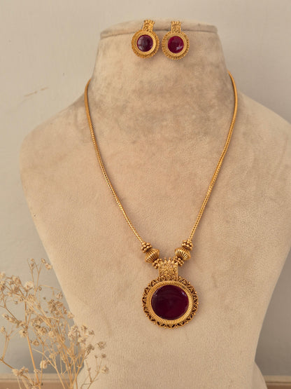 raditional gold chain necklace and matching round stud earrings with deep red stone centers