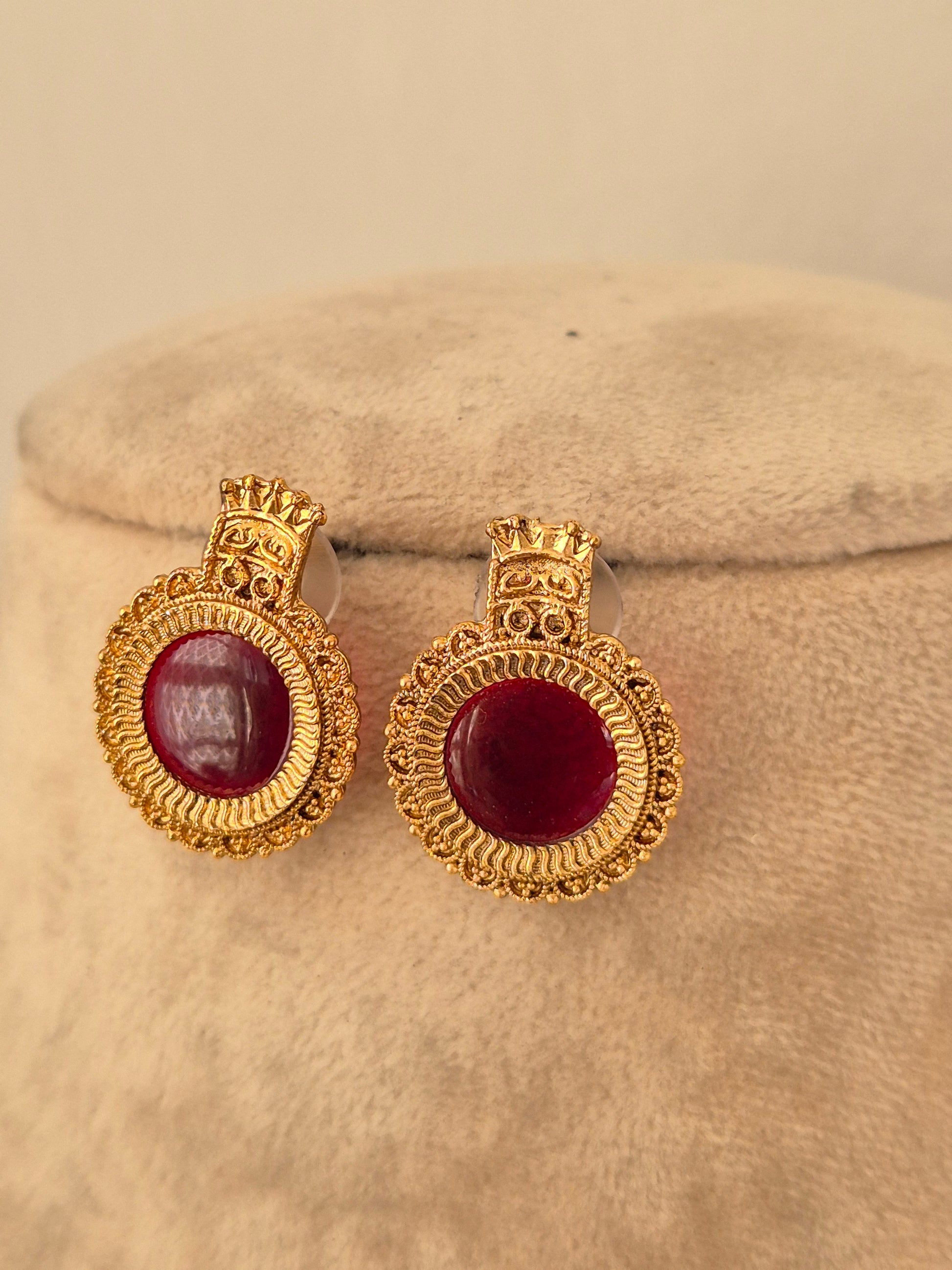 Traditional gold round stud earrings with deep red stone centers