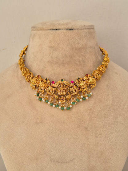Naitri Waraya Necklace Set crafted in gold-toned brass alloy with traditional temple design work and green stone accents.