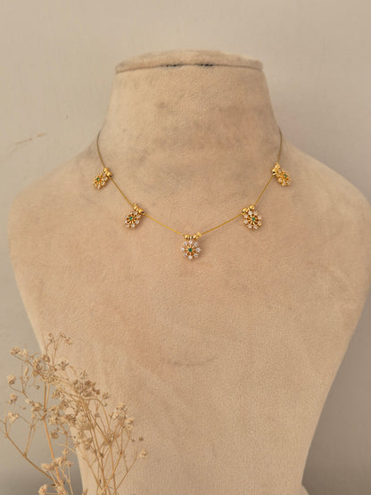 Descriptive & SEO-focused: Gold-finish invisible chain necklace featuring five floral stone-studded motifs with subtle green accents