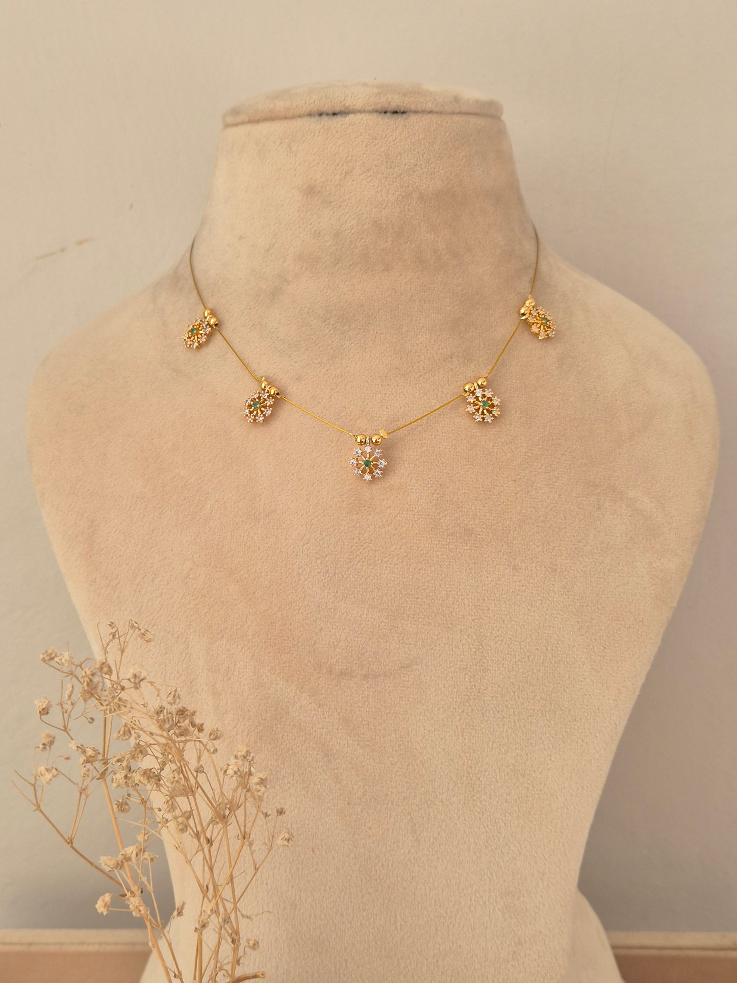 Delicate invisible gold chain necklace adorned with floral stone charms