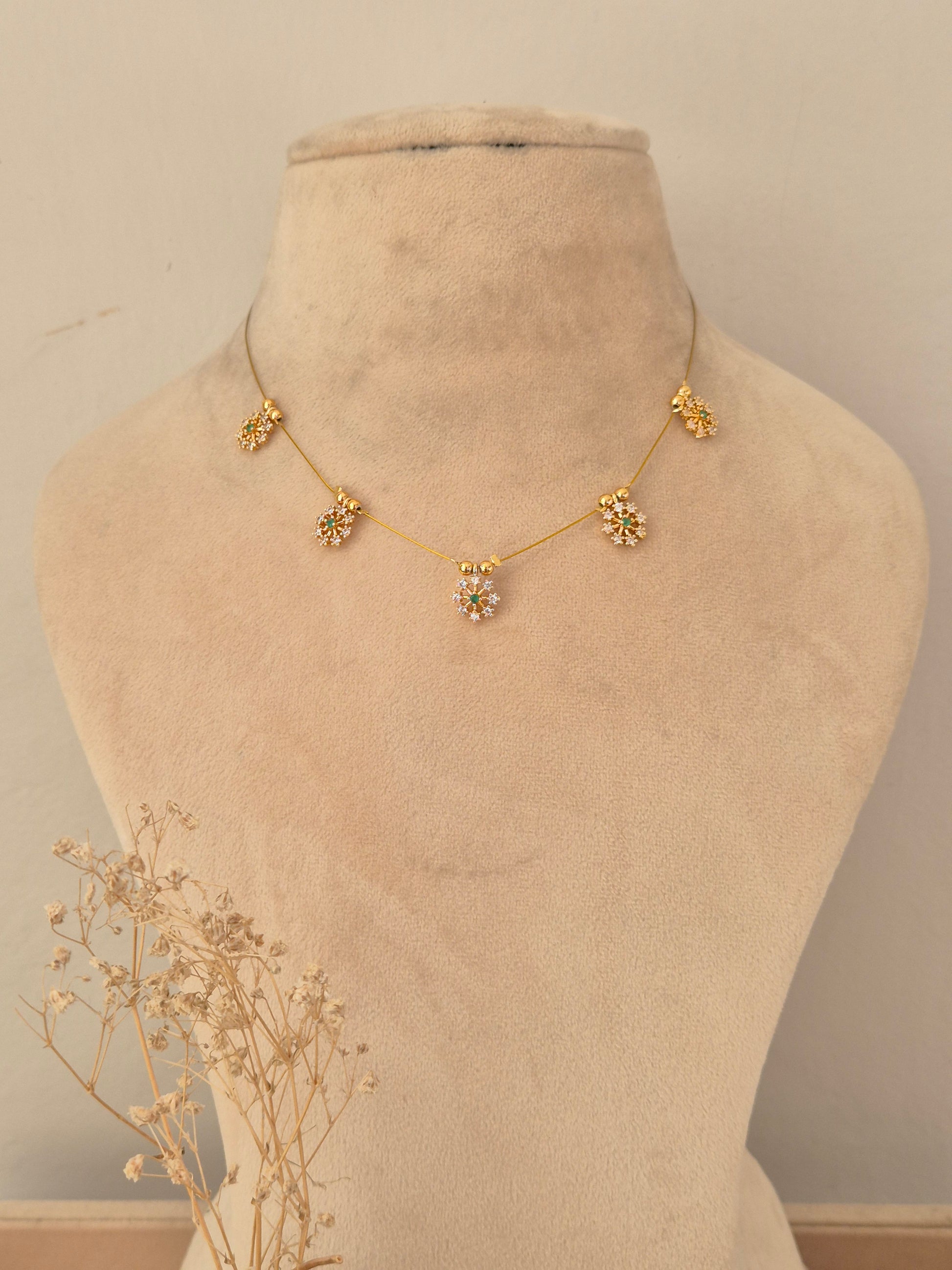 Delicate invisible gold chain necklace adorned with floral stone charms