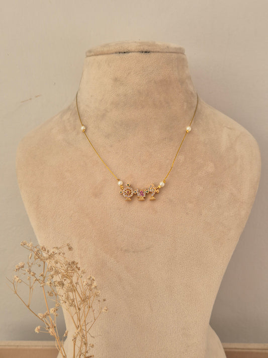 
 Delicate gold-toned invisible chain necklace featuring three temple-inspired charms with pink and white stone accents and pearl station beads