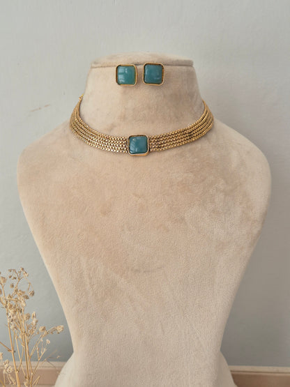Jasoda Necklace Set featuring a multi-strand golden mesh choker with a central square teal stone and matching square teal stud earrings