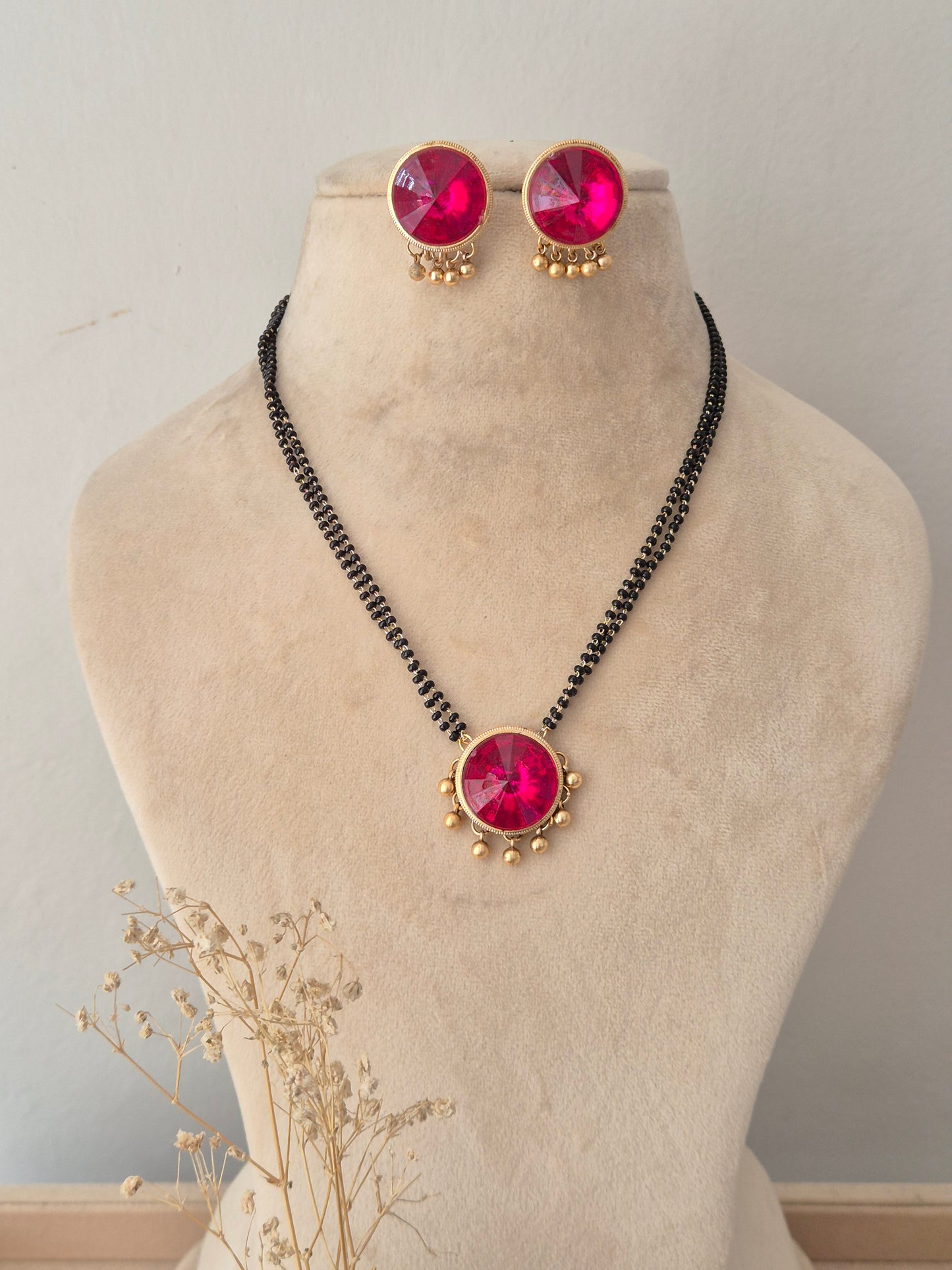 Elegant ethnic black chain necklace with a focal pink stone pendant and matching earrings for special occasions