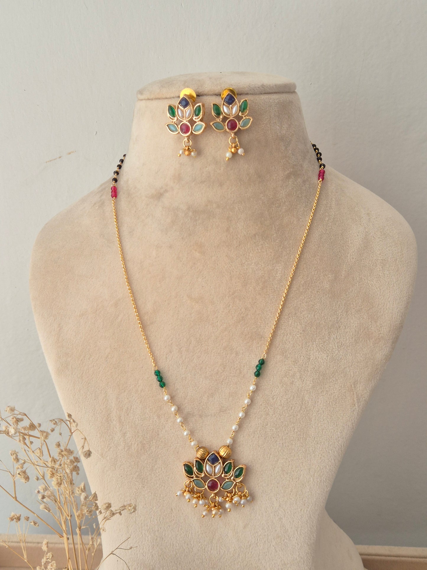 Naitri Luvina Necklace Set – Ethnic gold-plated chain necklace with a multi-colored stone lotus pendant and matching lotus-motif stud earrings