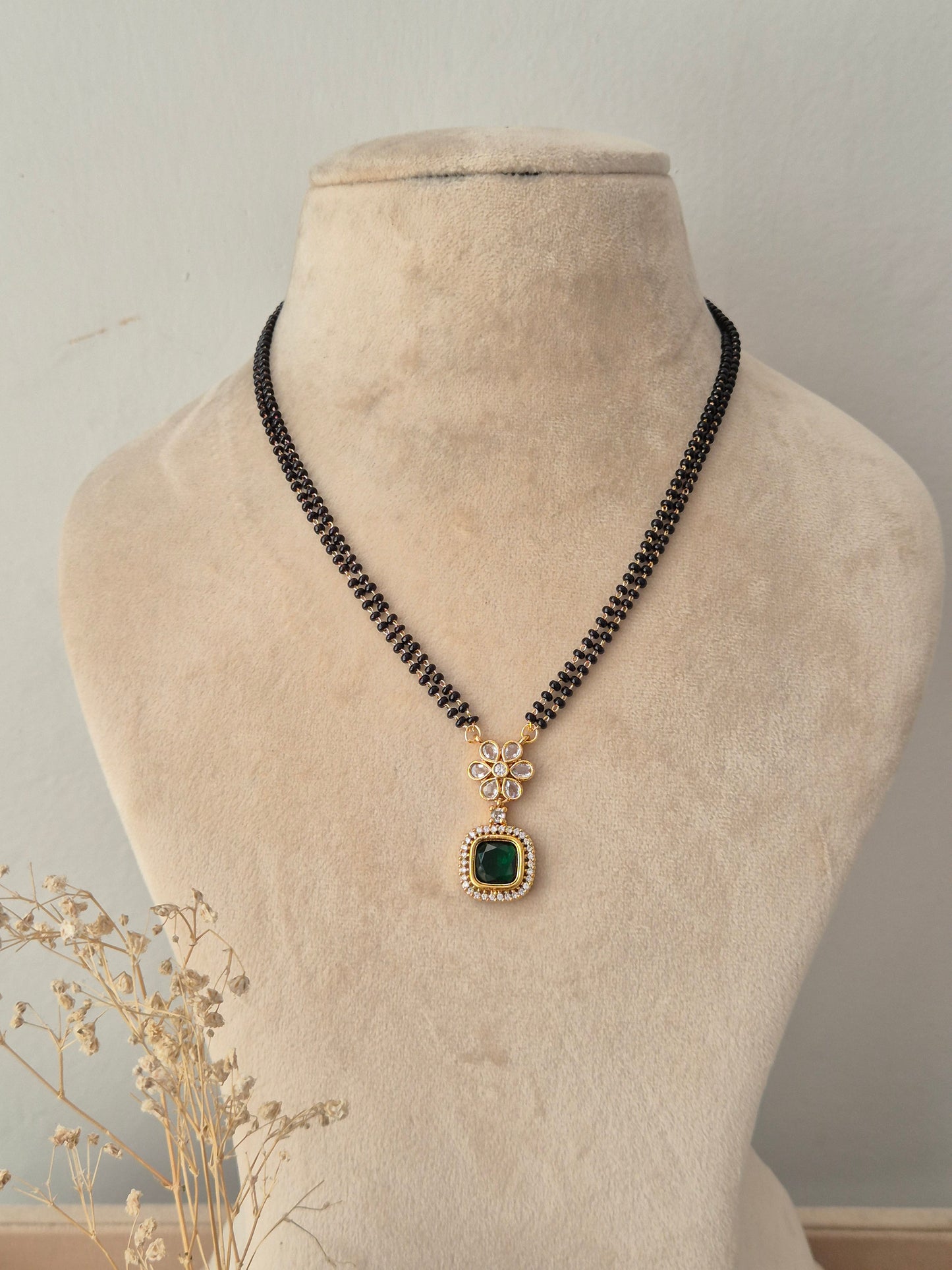 Traditional black-beaded Saloni Mangalsutra with a gold floral charm and square green pendant