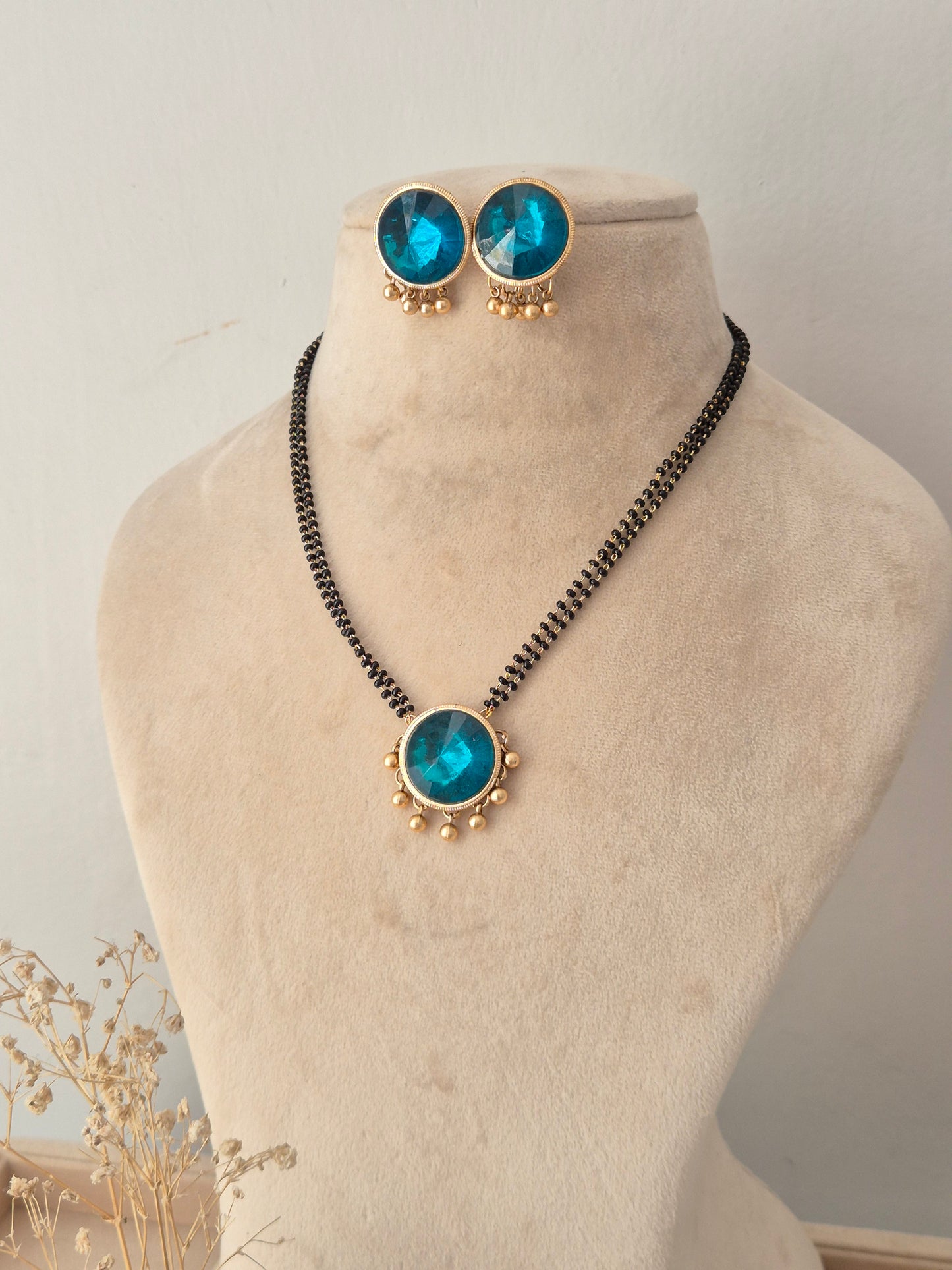 Preyasi Mangalsutra set with round blue stone pendant, matching stud earrings, and black beads necklace by Naitri
