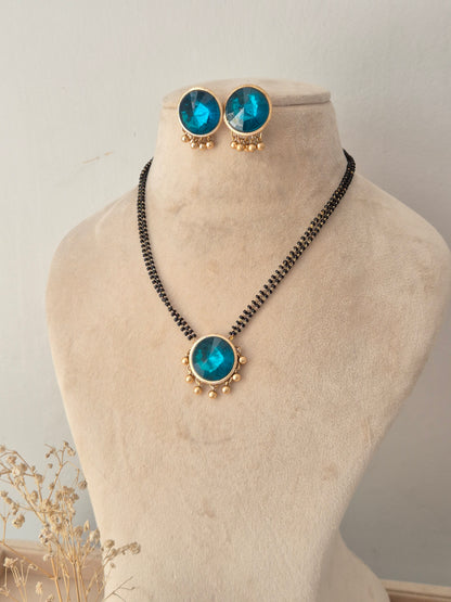 Preyasi Mangalsutra set with round blue stone pendant, matching stud earrings, and black beads necklace by Naitri