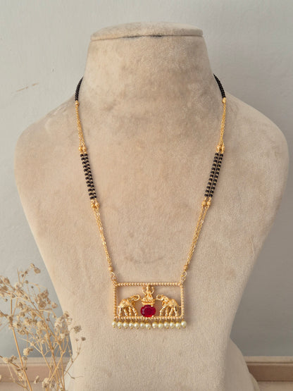 Traditional gold Jivinta Mangalsutra with an ornate rectangular elephant motif pendant, red stone, pearl drops, and black-beaded chain