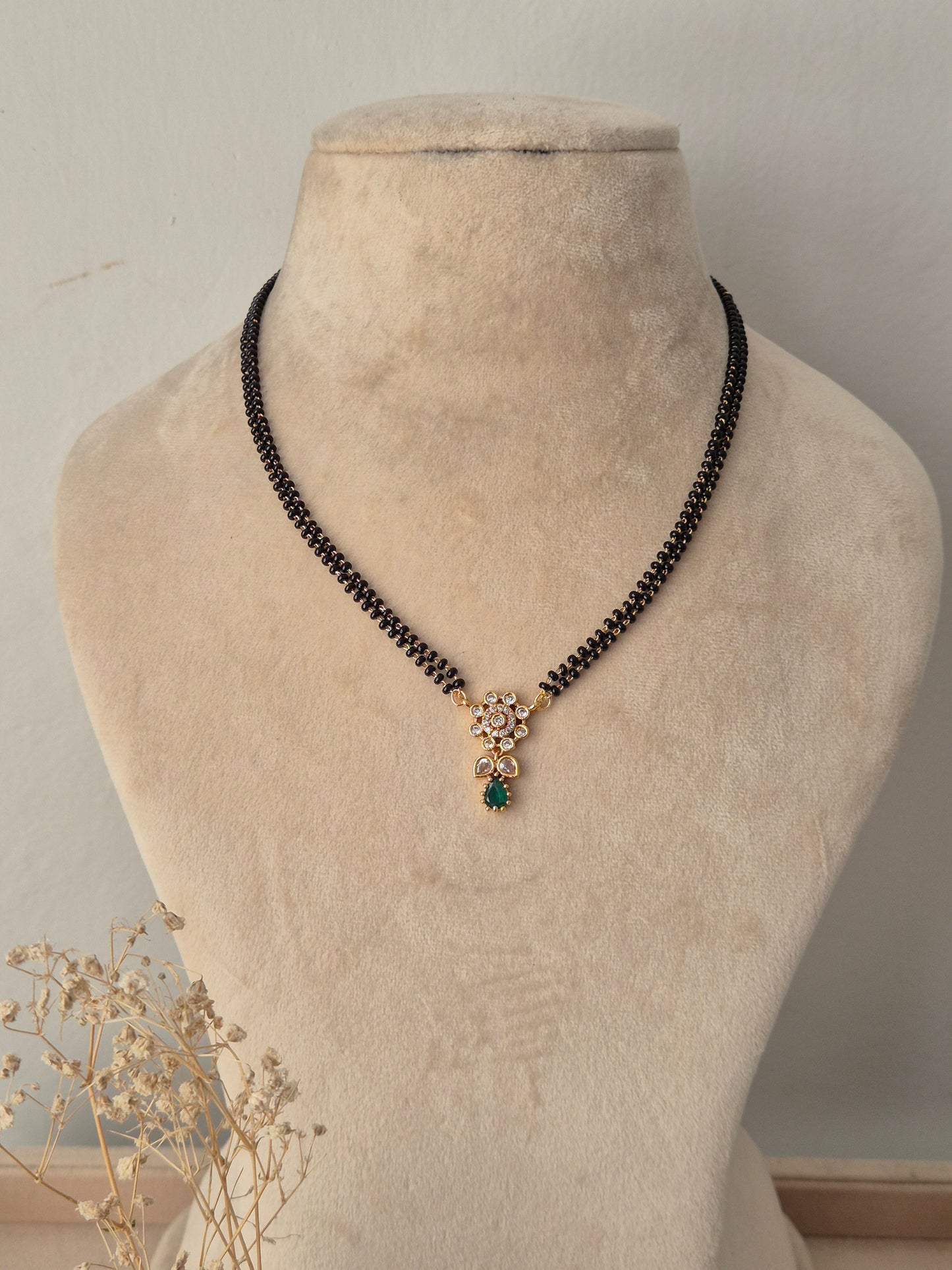 Balaka Mangalsutra gold floral pendant with green teardrop stone drop and black beads chain by Naitri