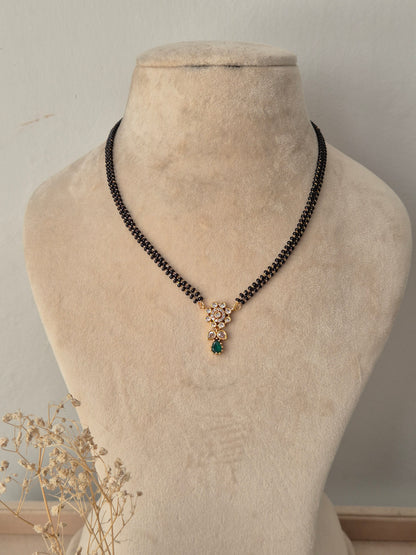 Balaka Mangalsutra gold floral pendant with green teardrop stone drop and black beads chain by Naitri