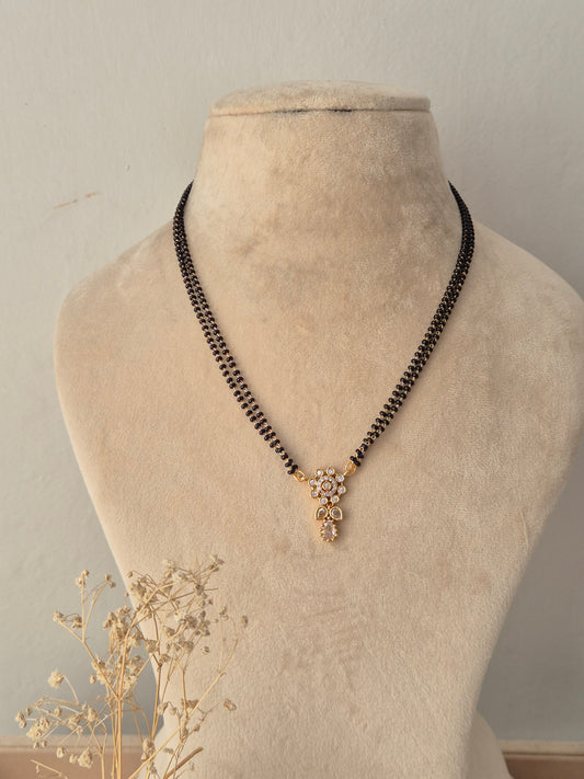 Traditional Chetasi Mangalsutra with a gold flower-shaped CZ pendant and double-strand black beads chain