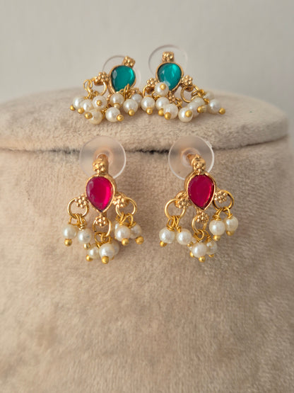 Reversible gold-toned stud earrings featuring teardrop pink stones on one side and green stones on the reverse, bordered by dangling pearl bead clusters