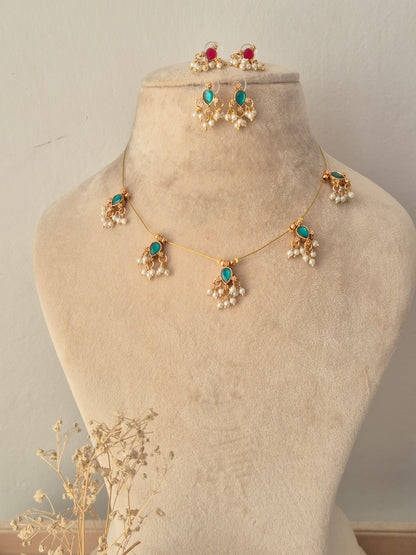 Gold-toned invisible chain necklace set with pink stone motifs and pearl cluster drops