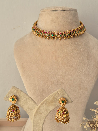 Alpana Choker Necklace Set featuring a gold beaded choker with pink and green stones, paired with matching jhumka earrings