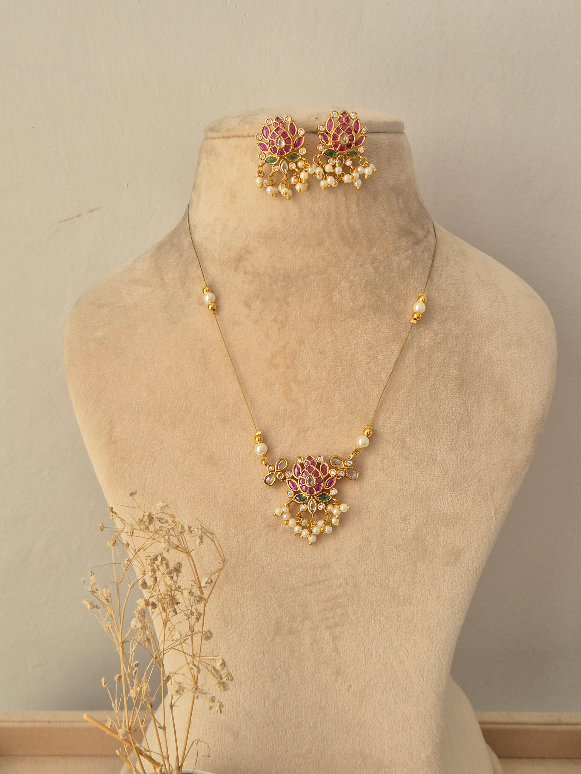 Ludhika Necklace Set featuring a gold chain with a lotus floral pendant, pearl drops, and matching stud earrings