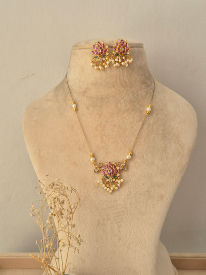 Ludhika Necklace Set featuring a gold chain with a lotus floral pendant, pearl drops, and matching stud earrings