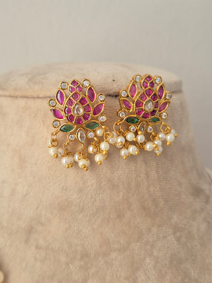 Pair of gold lotus-shaped stud earrings with pink stones, green accents, and pearl drops from the Ludhika Necklace Set