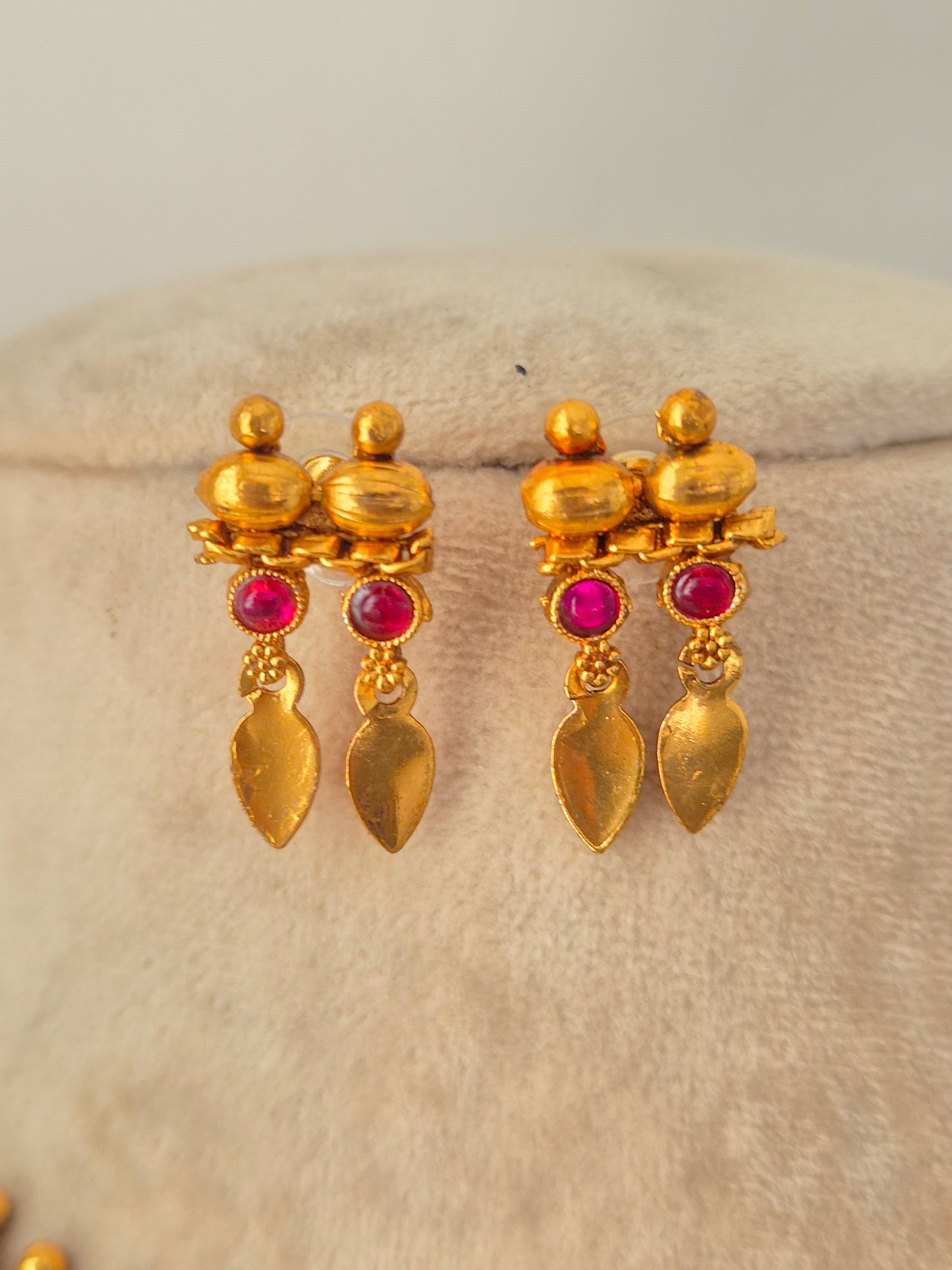 Pair of antique gold drop earrings with pink stones and dangling leaf charms from the Pahal Necklace Set.