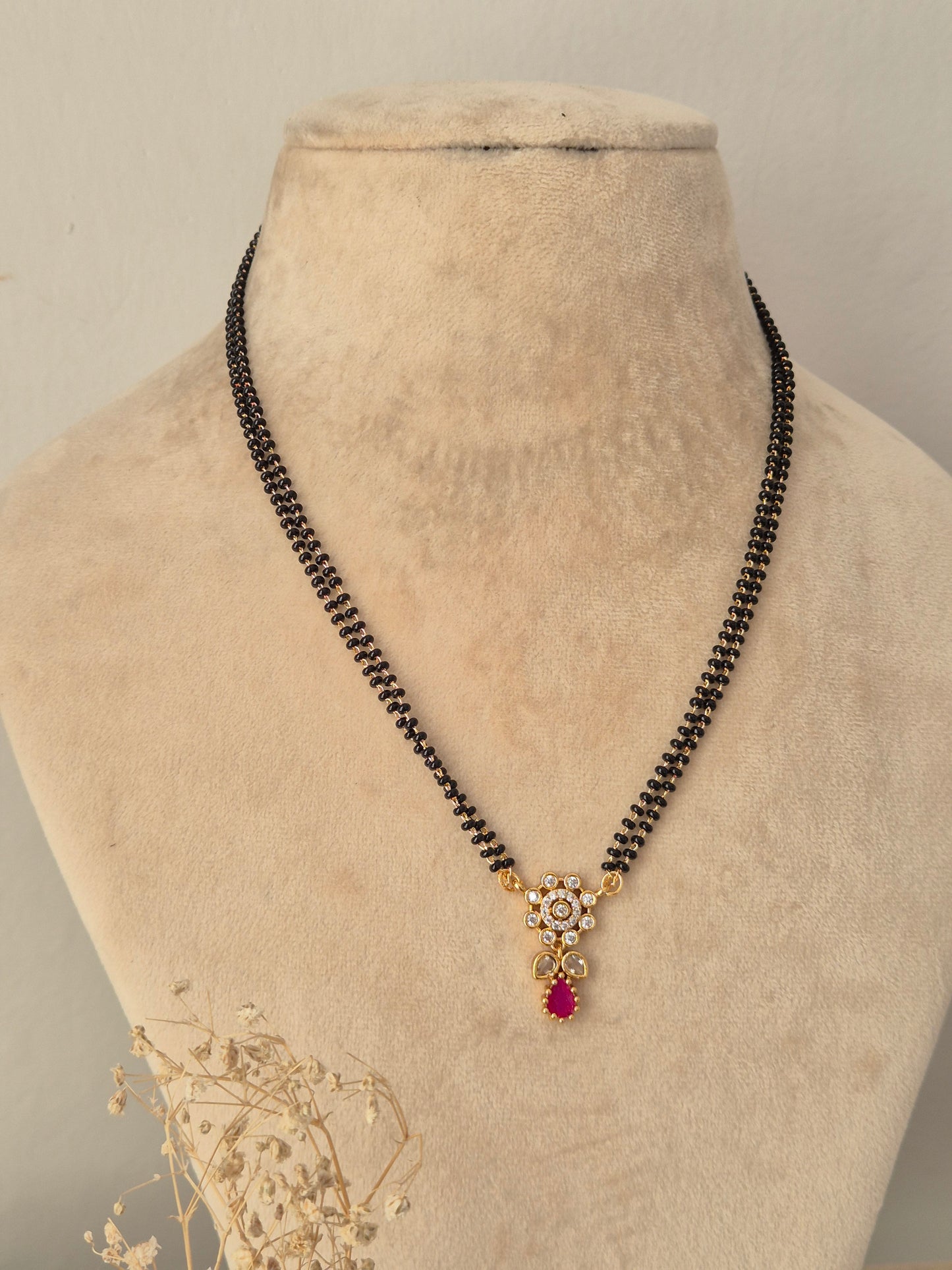 Sitika Mangalsutra gold floral CZ pendant with pink teardrop stone and black bead chain by Naitri.