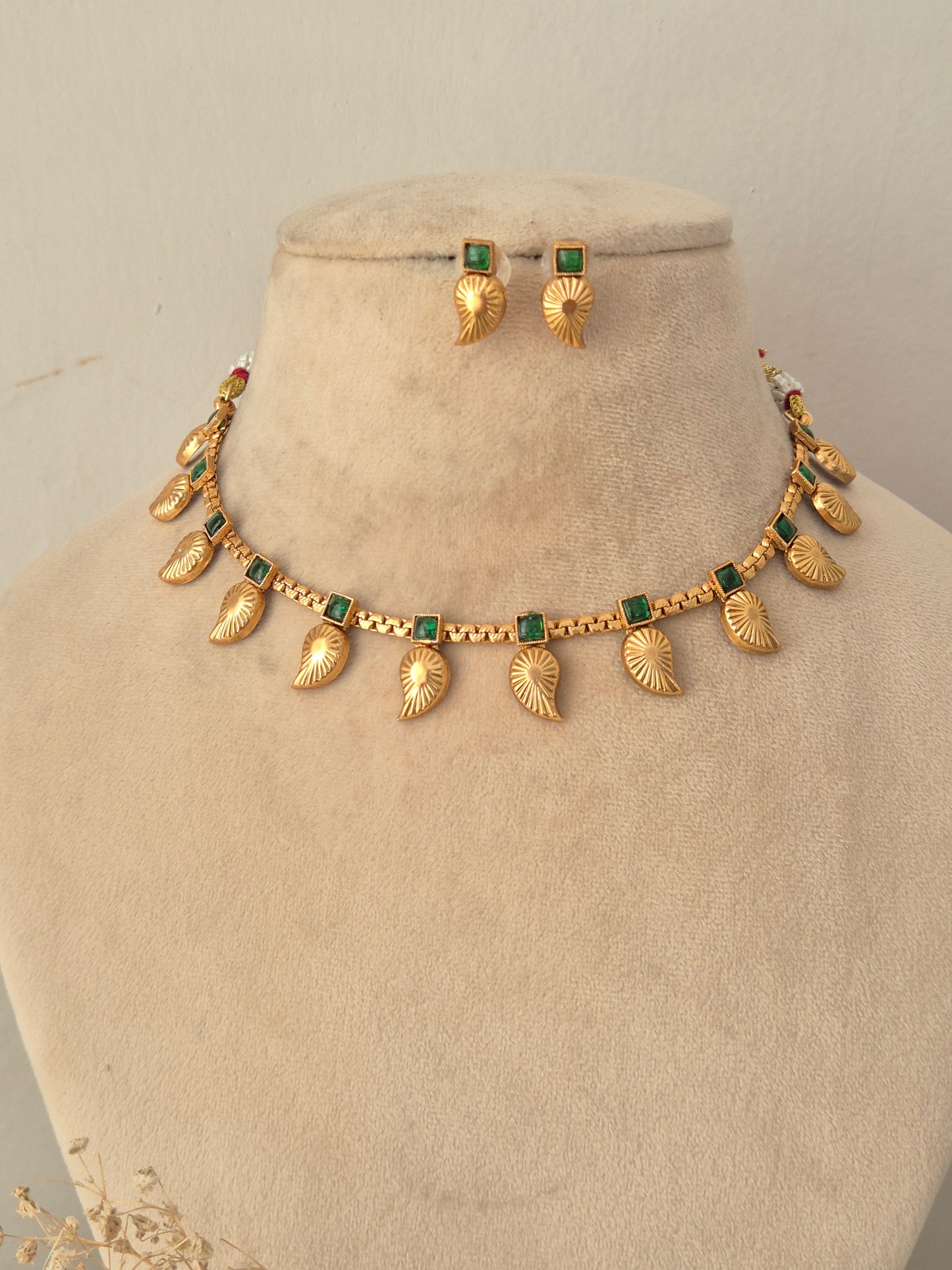 Tanvika Necklace Set antique gold choker with green stones, leaf charms, and matching drop earrings by Naitri