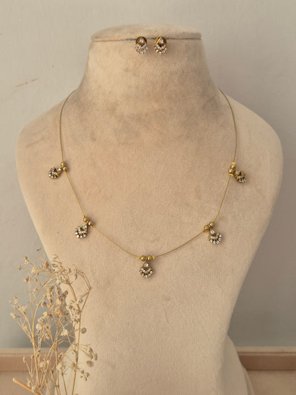 Ishrat Invisible Necklace Chain Set featuring a delicate gold-toned chain with five CZ charm pendants and matching stud earrings