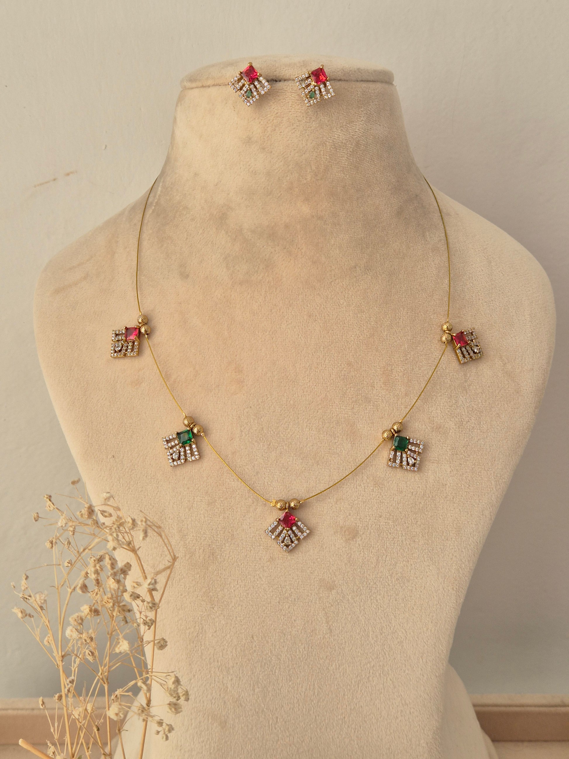 Labdhi Invisible Necklace Chain Set featuring a gold wire chain with colorful stone pendants and matching stud earrings