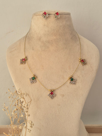 Labdhi Invisible Necklace Chain Set featuring a gold wire chain with colorful stone pendants and matching stud earrings