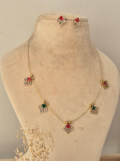 Labdhi Invisible Necklace Chain Set gold wire necklace with red and green CZ stone charms and matching stud earrings by Naitri