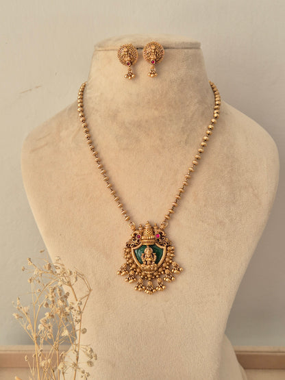 Charumati Necklace Set featuring an antique gold beaded long chain with a Goddess Lakshmi green enamel pendant and matching stud earrings