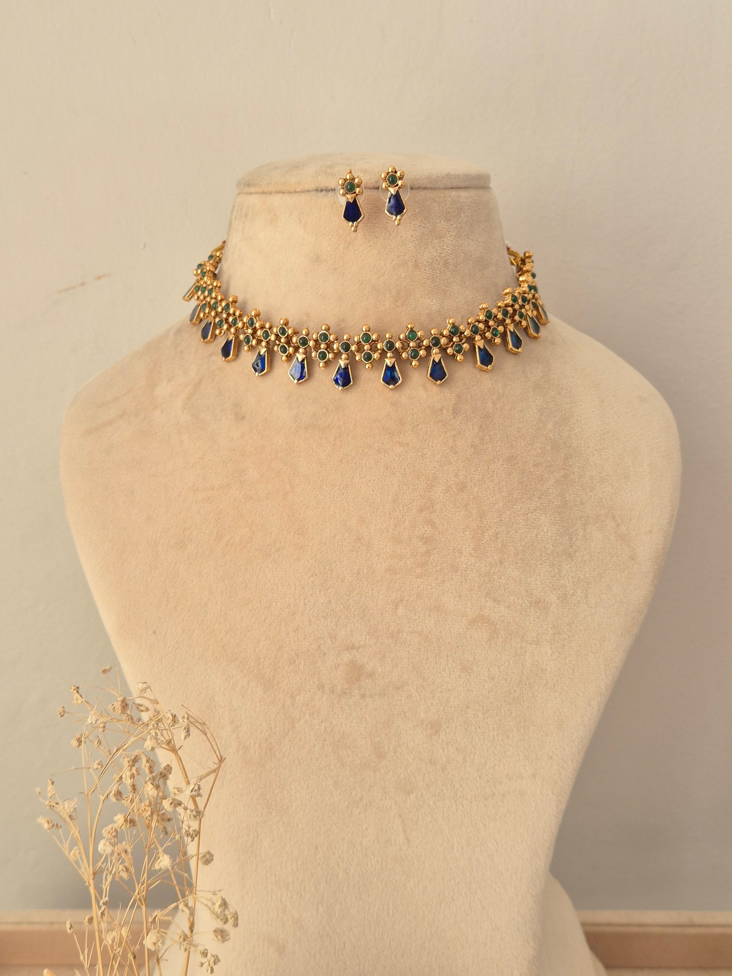 Ehsaas Necklace Set featuring a gold choker with dark green stone accents and dangling pearl beads, paired with matching drop earrings.