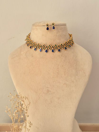 Ehsaas Necklace Set featuring a gold choker with dark green stone accents and dangling pearl beads, paired with matching drop earrings.