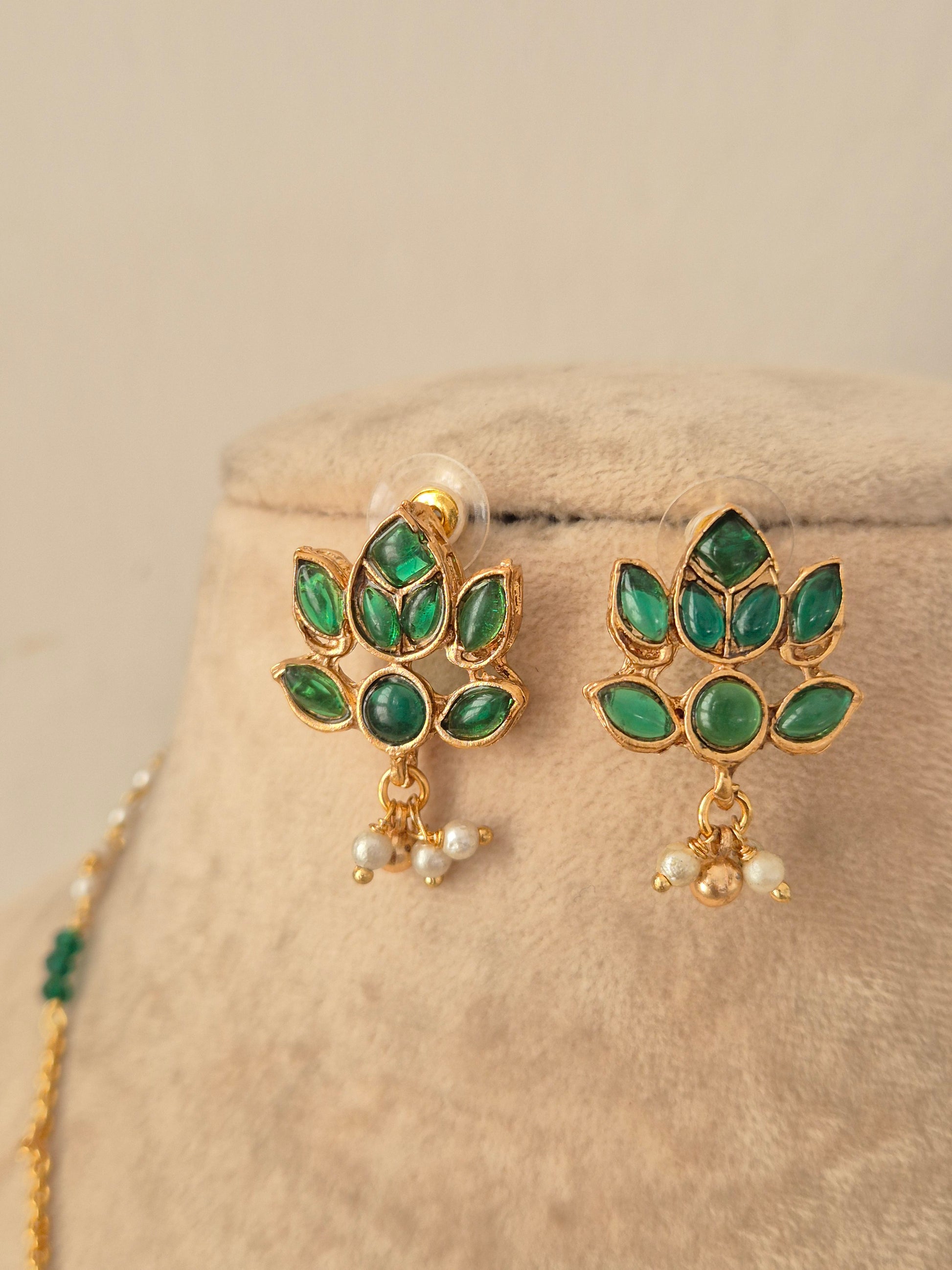 Pair of gold lotus stud earrings encrusted with green stones and pearl drops matching the Prabhati Necklace Set