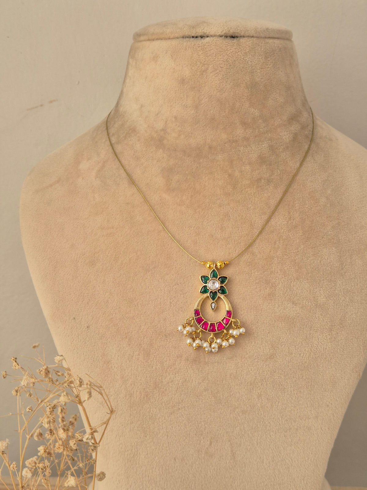 Traditional Indian bridal jewelry set crafted in antique gold with ruby-pink teardrop stones, featuring a wide choker necklace, matching chandelier drop earrings, and an intricate maang tikka ornament