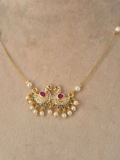Antique gold traditional jewelry set featuring a wide choker necklace with ruby-pink drop stones, matching chandelier earrings