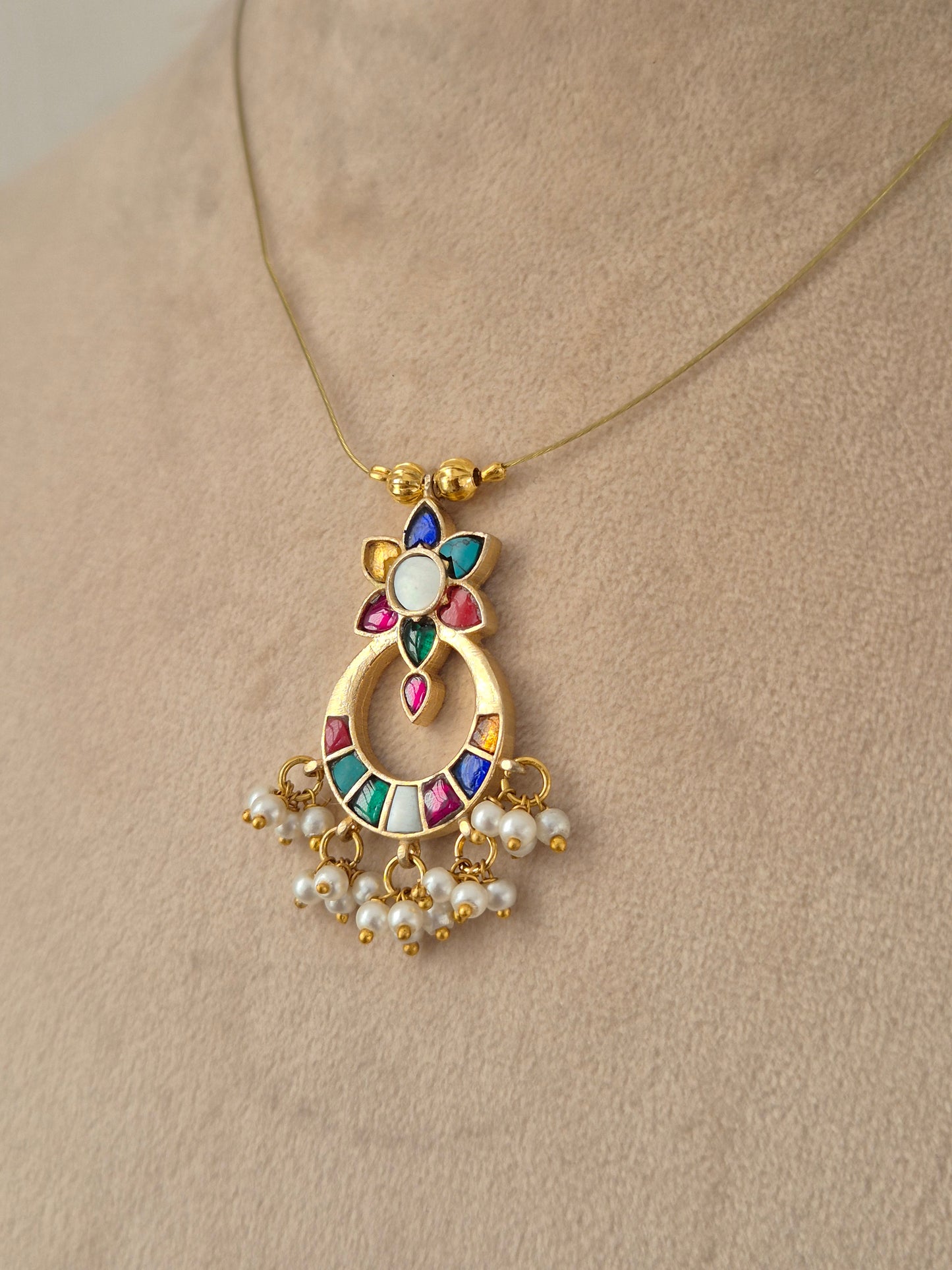 Detailed front view of an antique gold choker set featuring floral cluster accents, ruby-pink teardrop stones, and matching round stud earrings