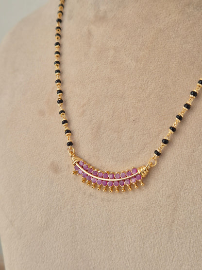 Traditional black-beaded long mangalsutra with ruby-pink stone accented pendant