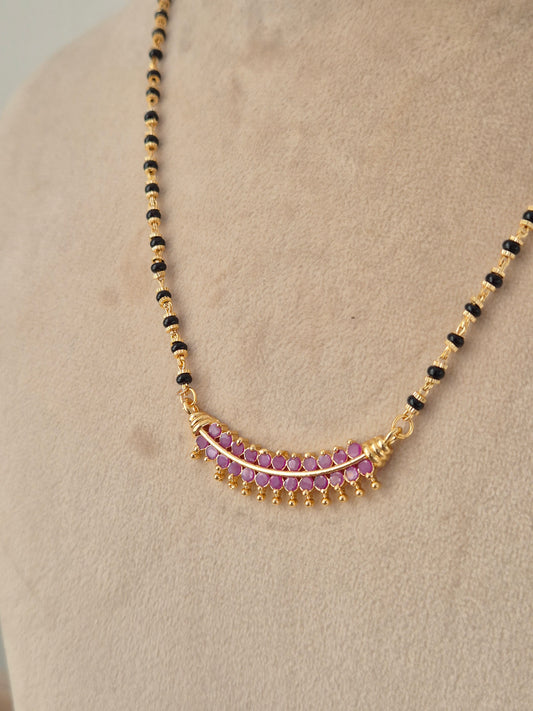 Traditional black-beaded long mangalsutra with ruby-pink stone accented pendant