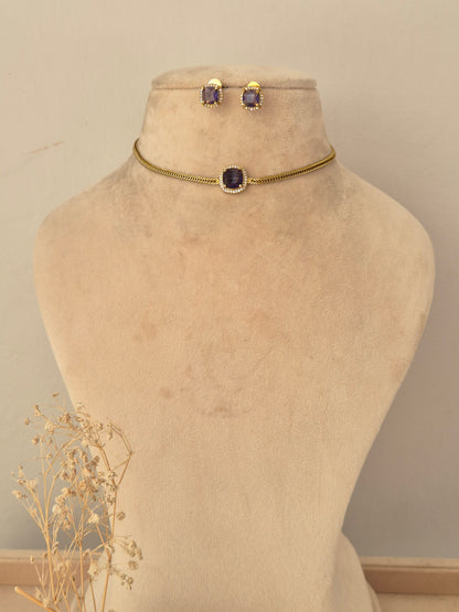 Antique gold long-chain mangalsutra featuring a detailed floral-motif pendant with ruby-pink teardrop stones, black bead strands, and matching stud earrings