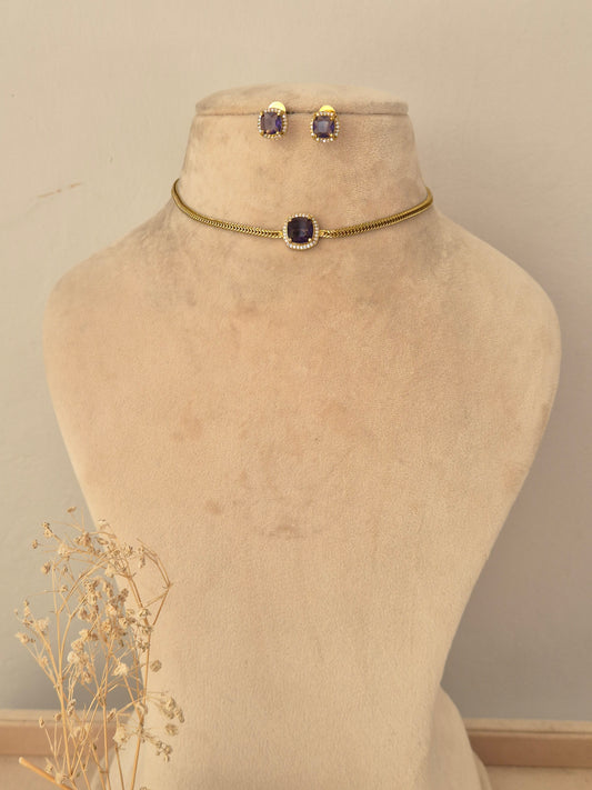 Antique gold long-chain mangalsutra featuring a detailed floral-motif pendant with ruby-pink teardrop stones, black bead strands, and matching stud earrings
