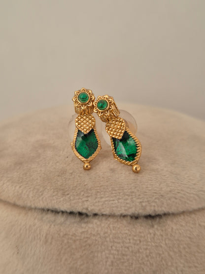 Close-up of antique gold temple choker with Goddess Laxmi coin motifs and emerald-green stone drops