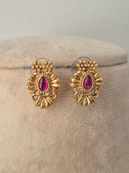 Option 1 (Short): Close-up of antique gold oval stud earrings set with teardrop ruby-pink stones